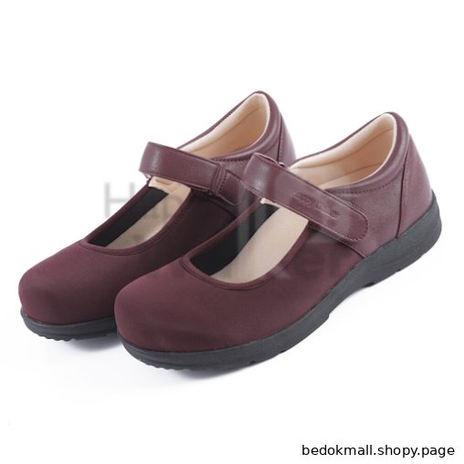 A pair of maroon Mary Jane style shoes on a white background.