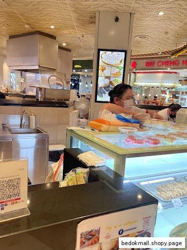 Interior view of a food stall with staff and food displays.