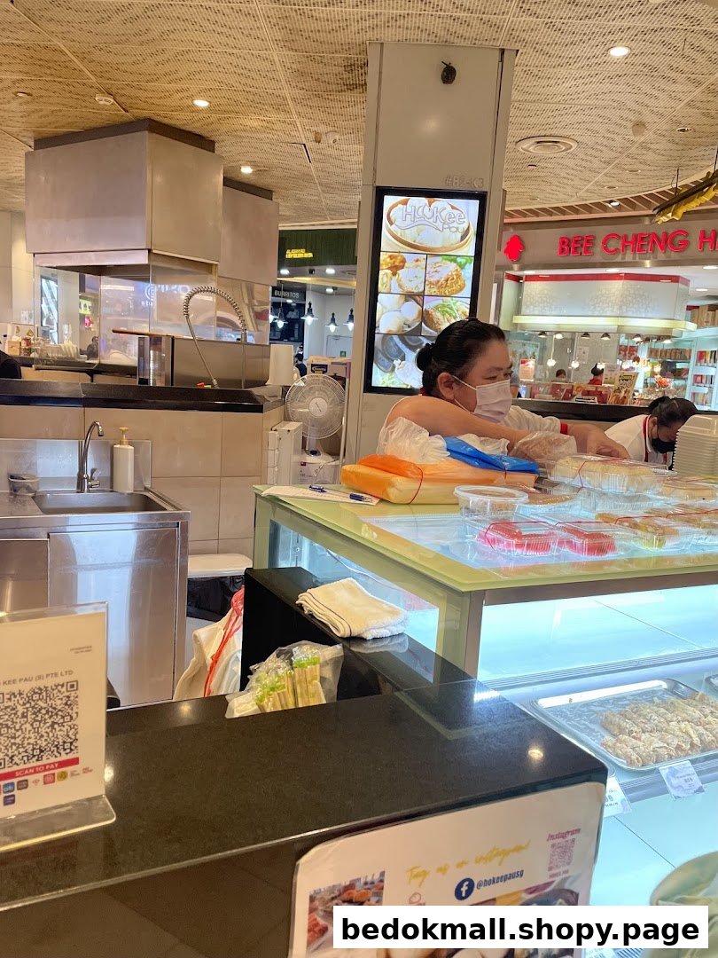 Staff working behind a counter with food displays in a shop interior.