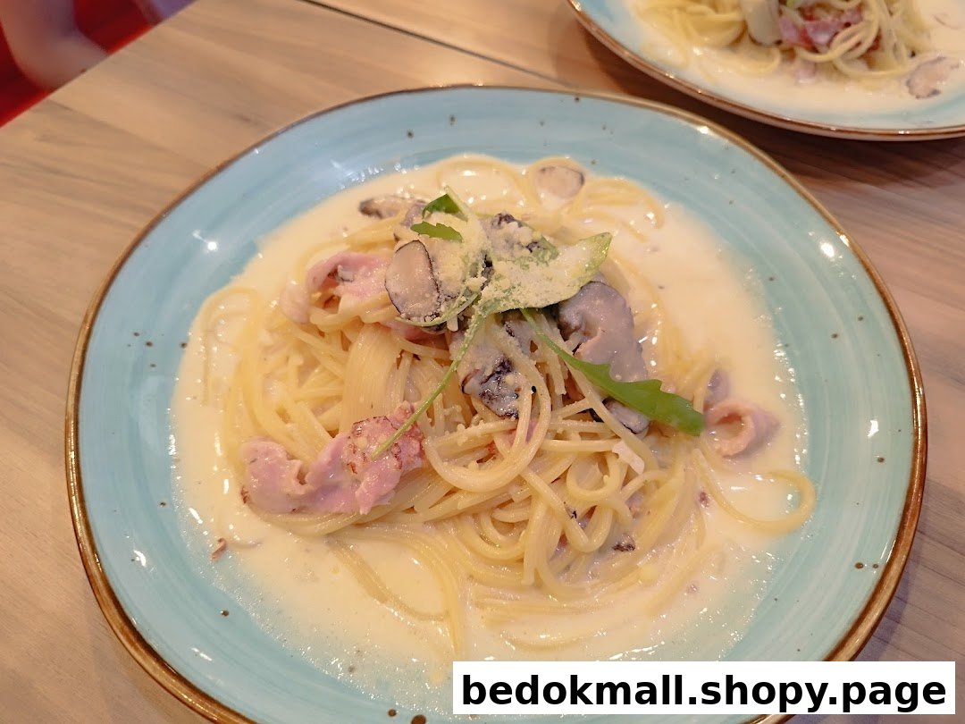 A plate of creamy pasta with mushrooms and bacon on a table.