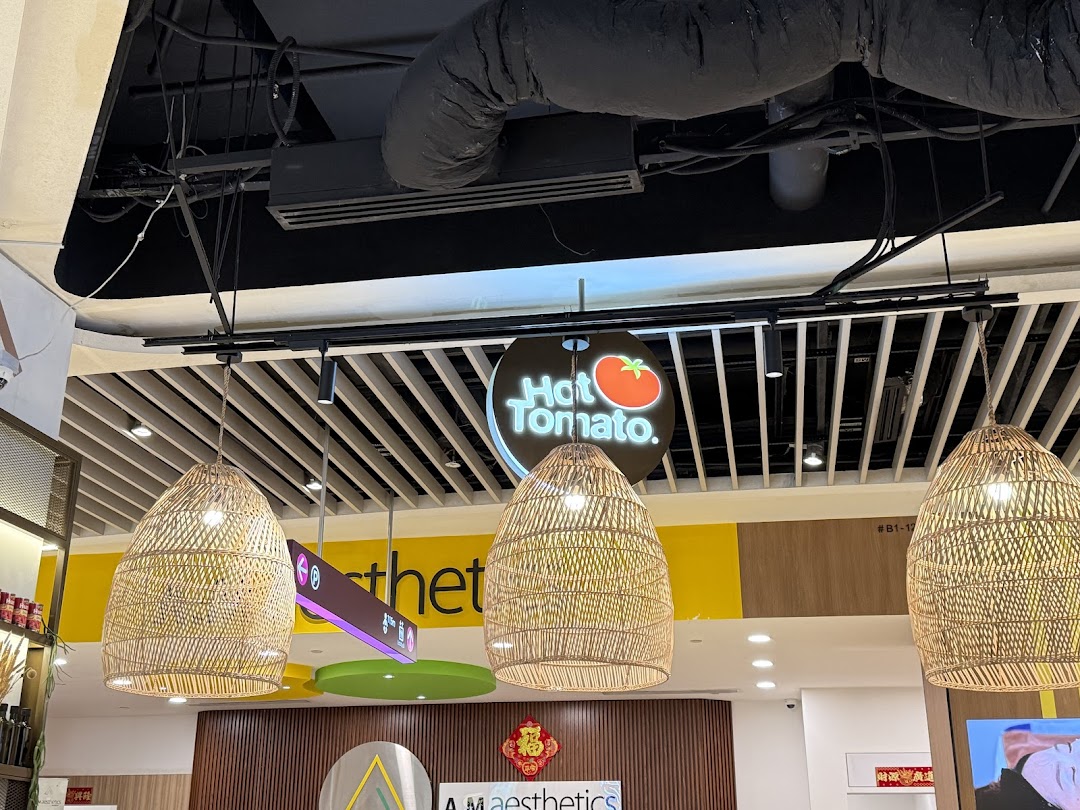 Hot Tomato Bistro sign and wicker lamps in a mall interior.