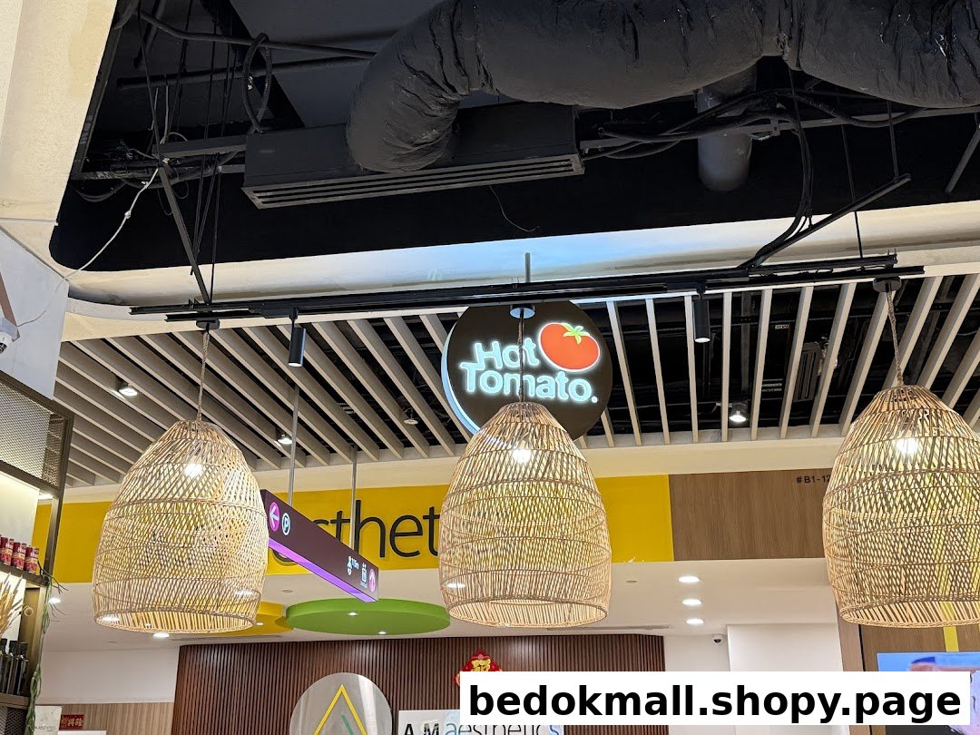 Hot Tomato Bistro sign and wicker lamps in a mall interior.