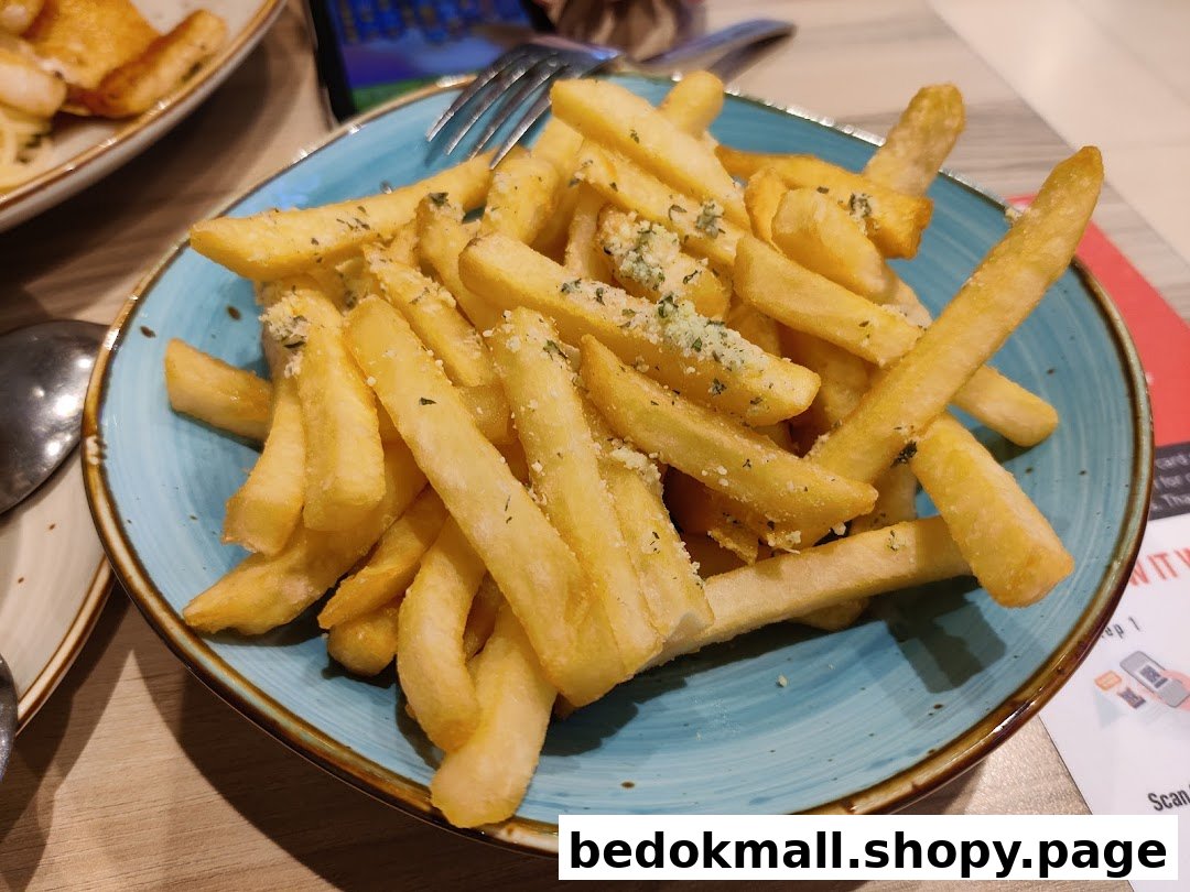 A blue bowl filled with french fries topped with herbs and cheese.