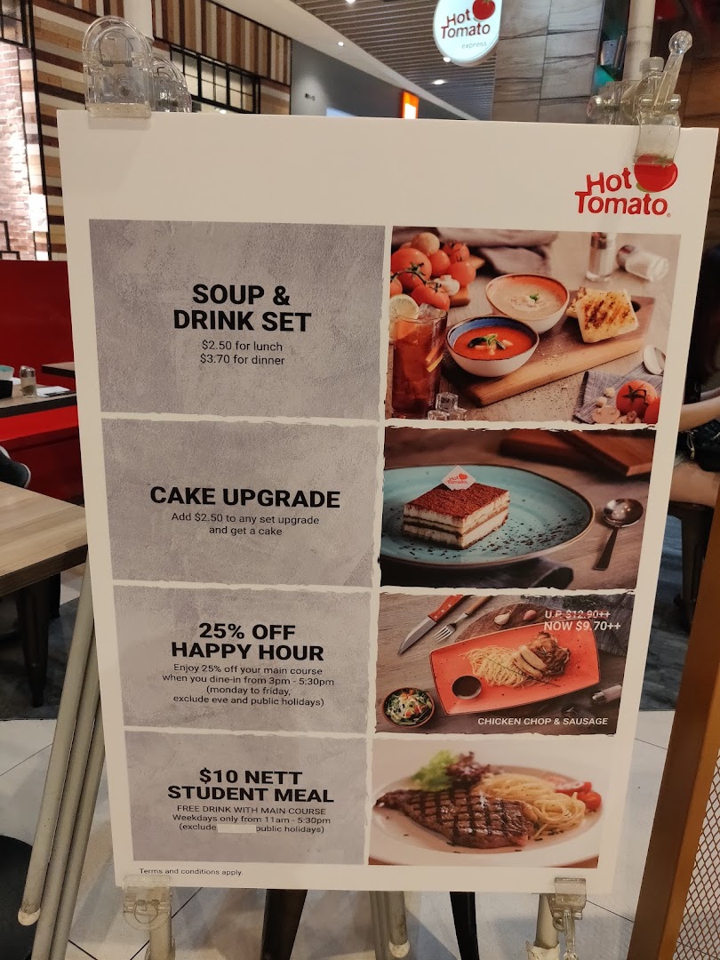 A large display board showing food items, prices, and promotions for Hot Tomato.