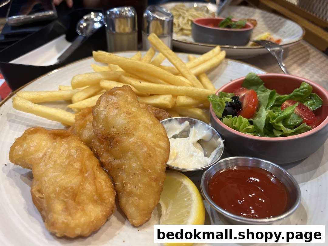 A plate of fish and chips with a side salad and sauces.