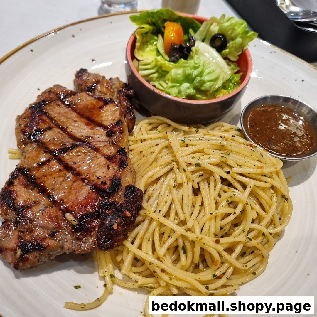 A plate of grilled steak, spaghetti, and a side salad with sauce.