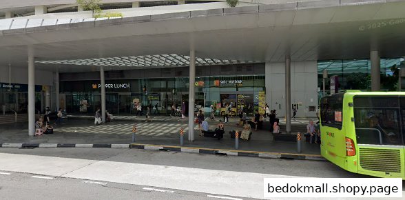 Exterior view of a mall entrance with people, a bus stop, and a bus.