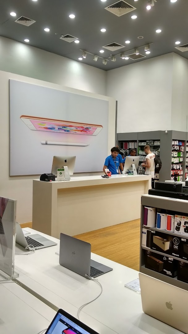 Interior view of an electronics shop with staff, display products, and a counter.