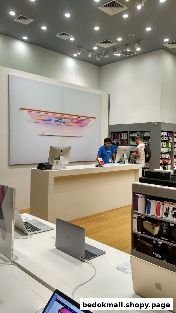 Interior view of an electronics shop with staff, display products, and a counter.