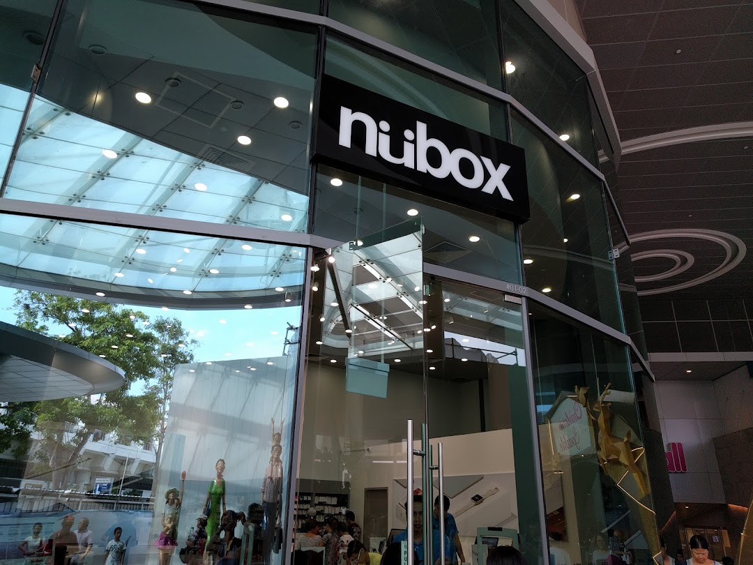 Glass-fronted shop entrance with 'nubox' sign and reflections.