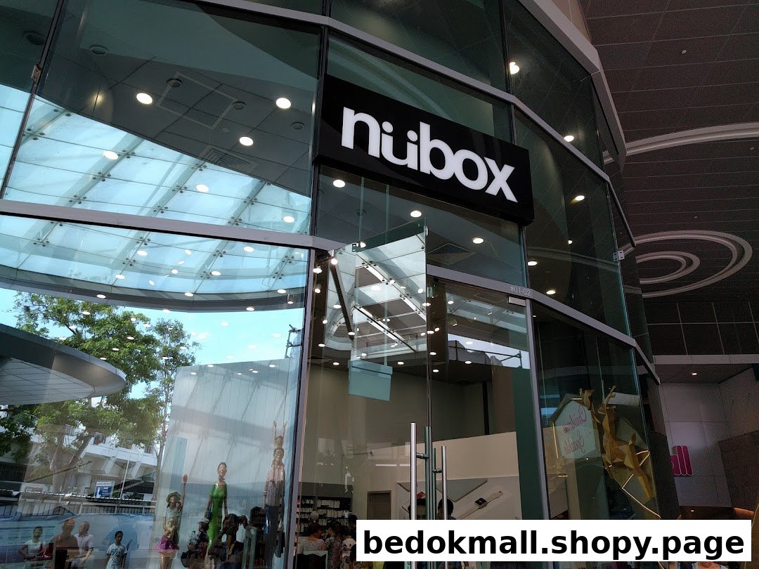 Glass-fronted shop entrance with 'nubox' sign and reflections.