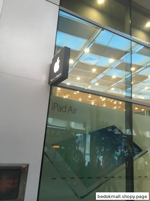 Exterior view of a shop with an Apple logo and 'iPad Air' on the glass.