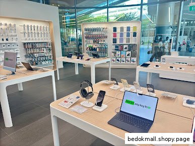 Interior view of an electronics retail store with display tables and accessories.