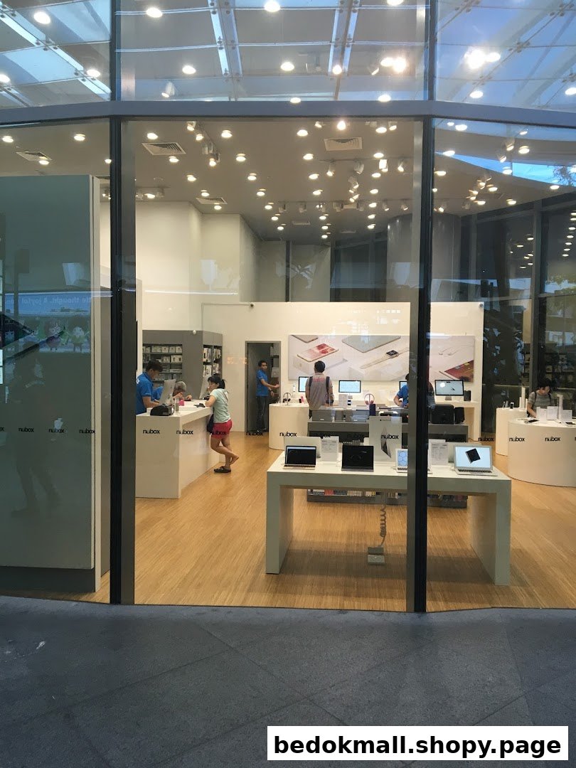 View into a modern electronics store with products and customers visible through glass.