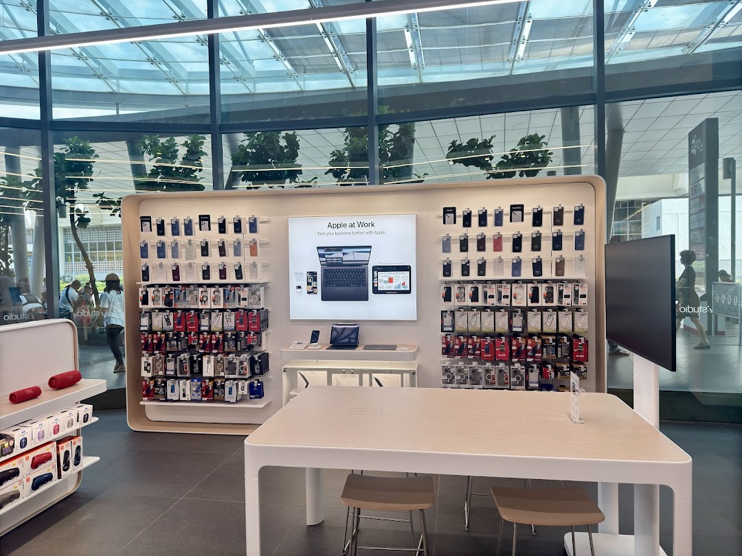 Interior view of a tech retail store with product displays and a large table.
