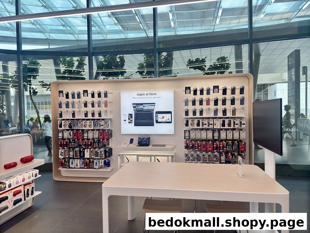 Interior view of a tech retail store with product displays and a large table.