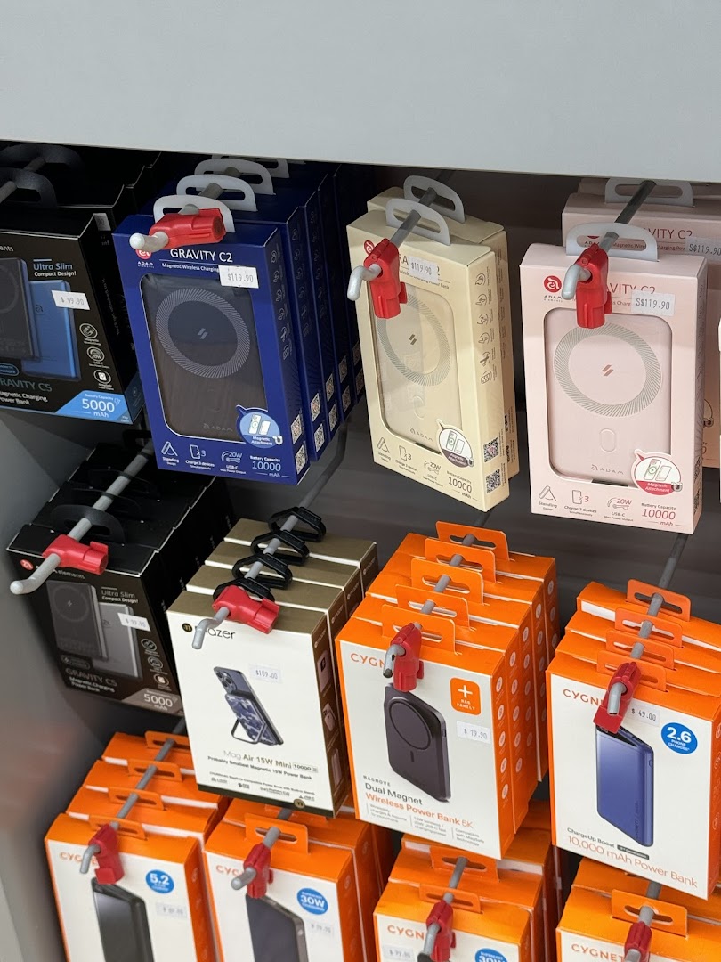 Electronic products in boxes are displayed on a retail shelf with prices.
