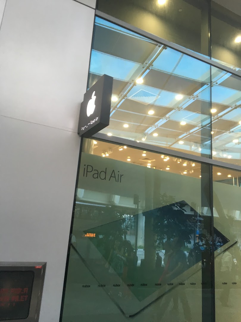 Exterior view of a shop with an Apple logo sign and 'iPad Air' on the window.