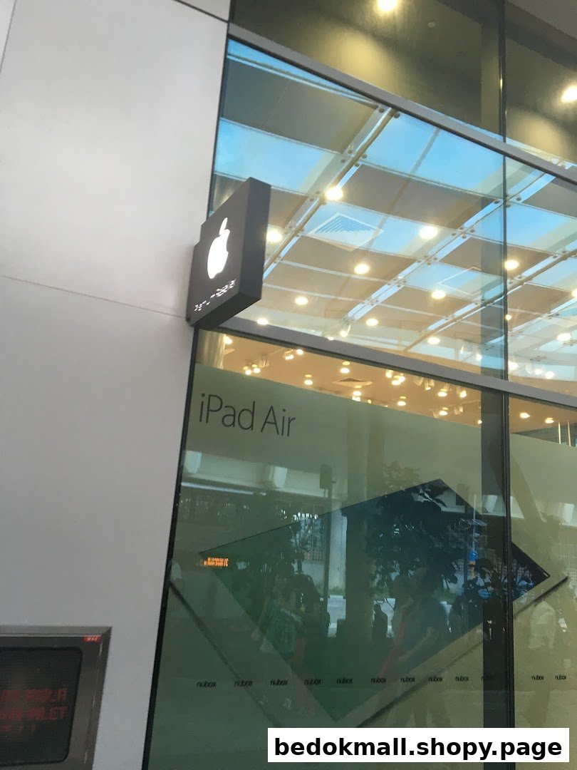 Exterior view of a shop with an Apple logo sign and 'iPad Air' on the window.