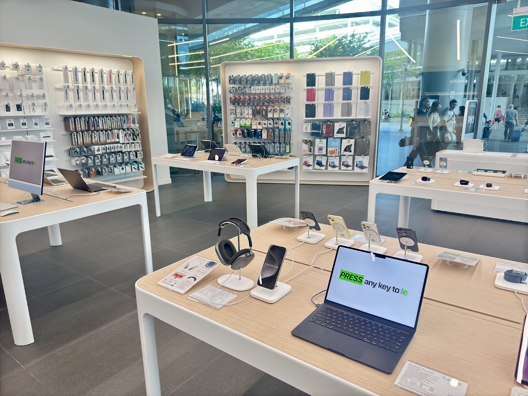 Interior view of an electronics store with display tables and wall-mounted products.