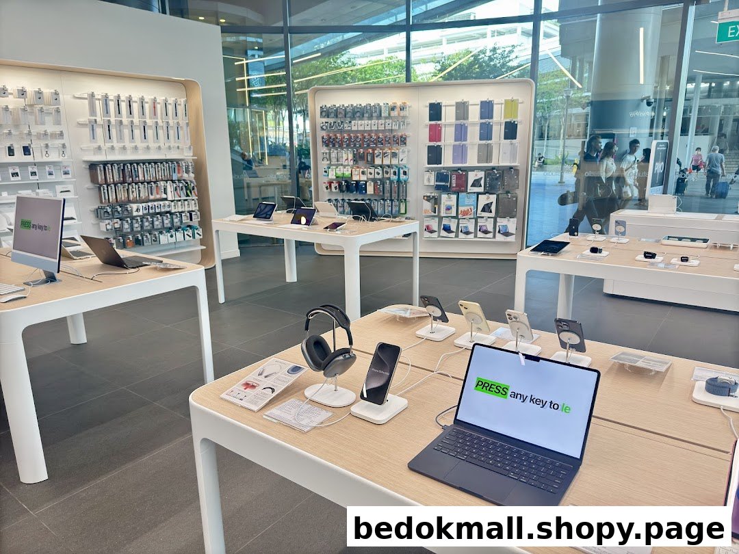 Interior view of an electronics store with display tables and wall-mounted products.