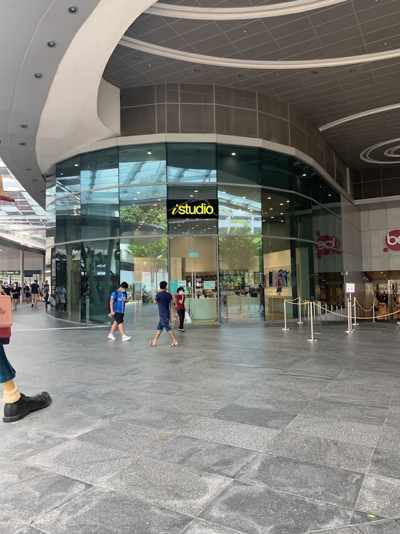 Exterior view of iStudio shop with glass facade and people walking by.