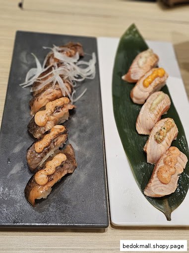 Two plates of various sushi and nigiri served on a table.