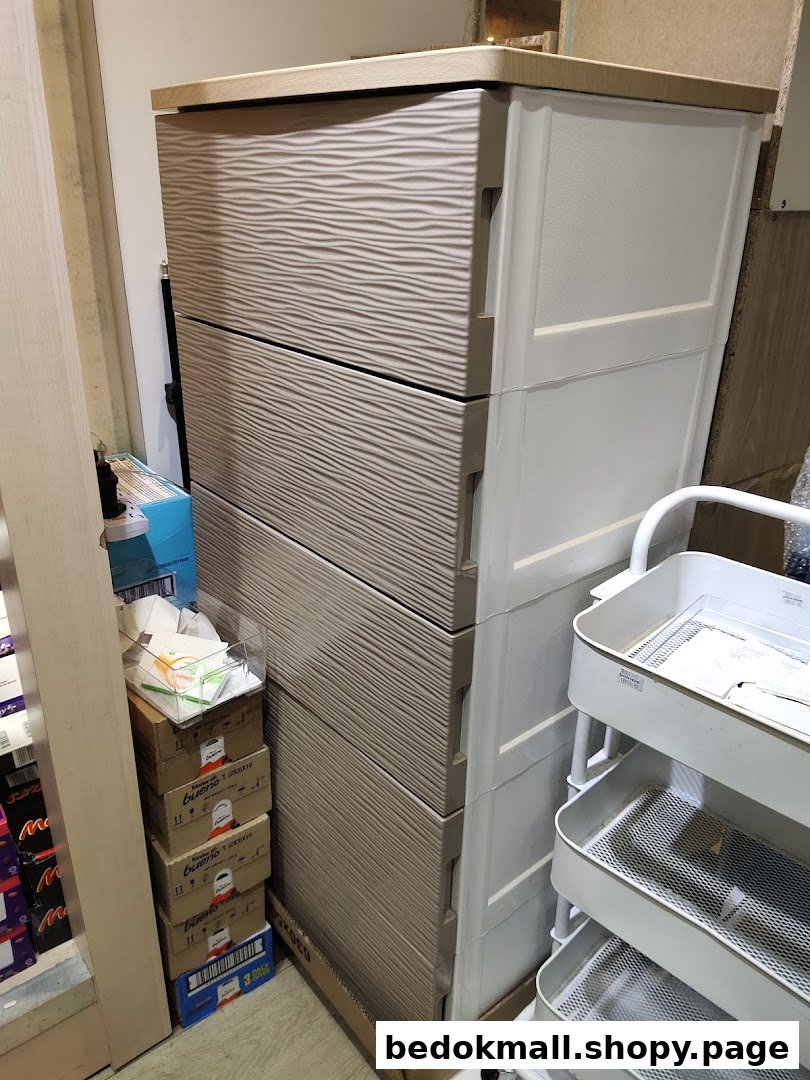 Plastic drawer units, cardboard boxes, and a rolling cart in a shop interior.