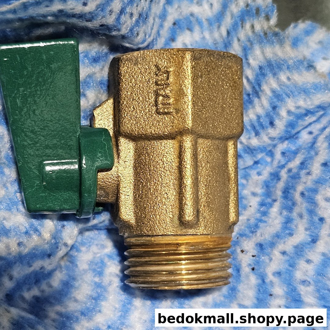 Close-up of a brass valve with a green handle and threaded end.