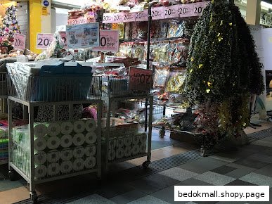 Shop interior with products on display and sale signs.