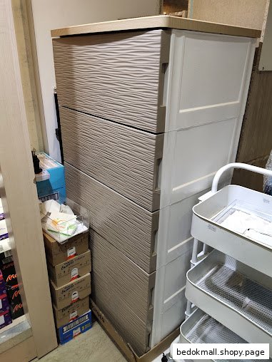 Two tall storage units and stacked boxes inside a shop.