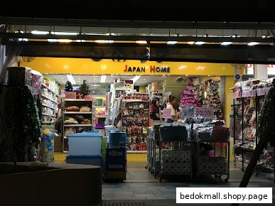 Exterior view of Japan Home shop entrance at night with products displayed.
