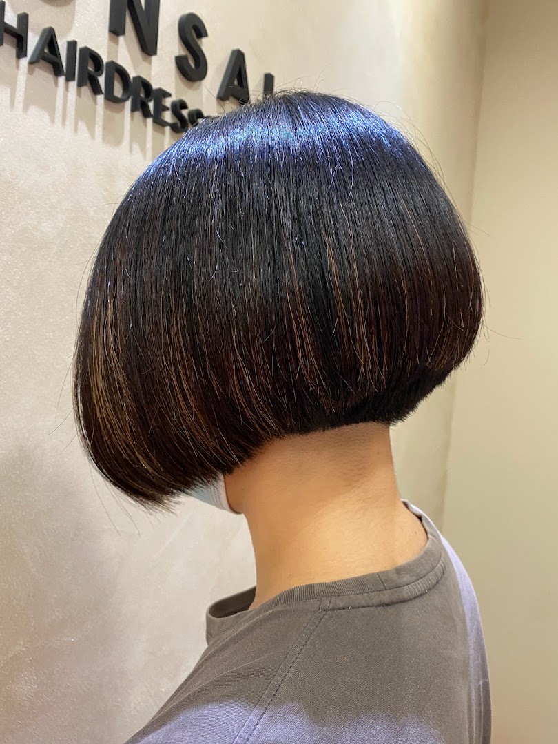 Back view of a person with a short, dark bob haircut.
