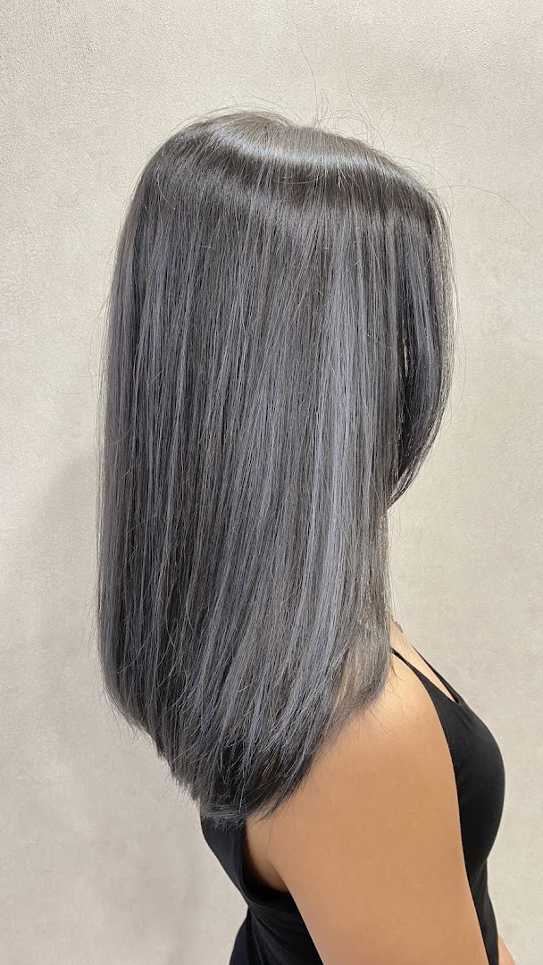 Back view of a person with long, straight grey/silver hair.