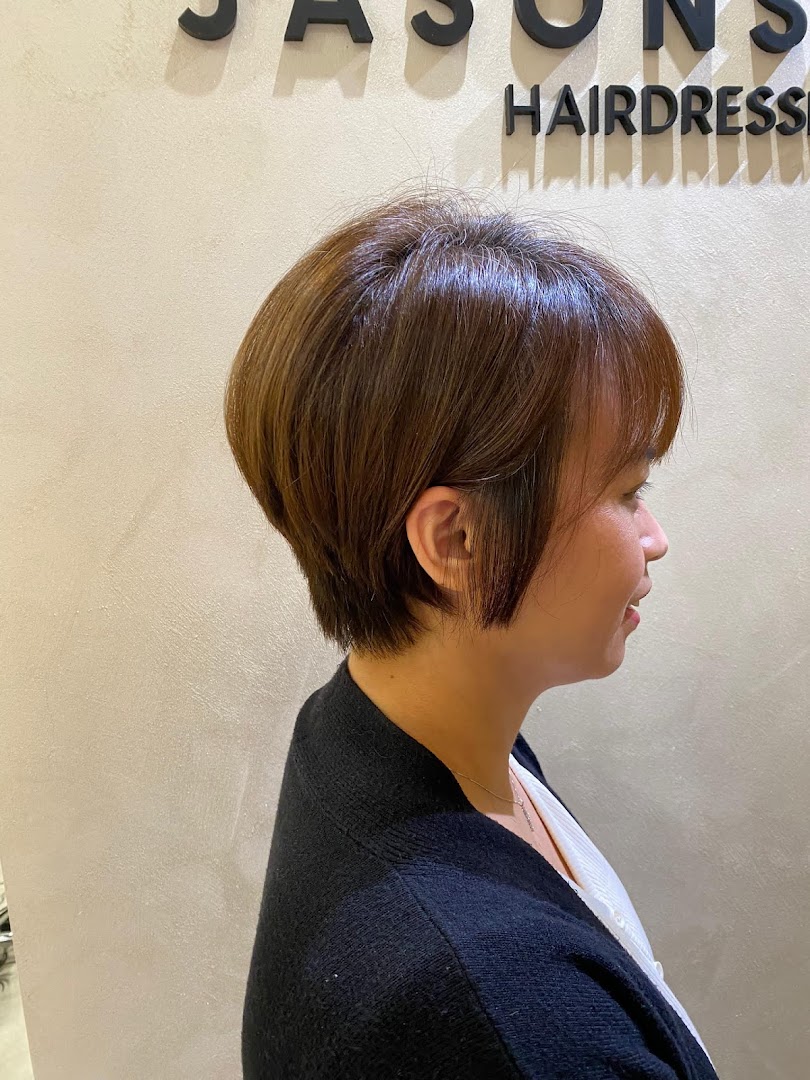 Side profile of a person with a short haircut inside a hair salon.