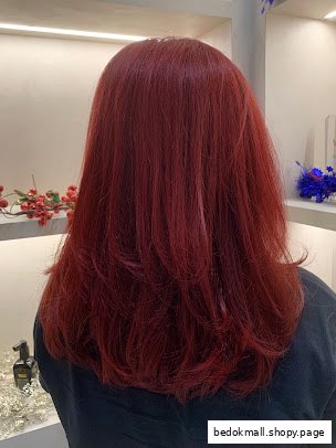 Back view of a person with long, vibrant red hair.