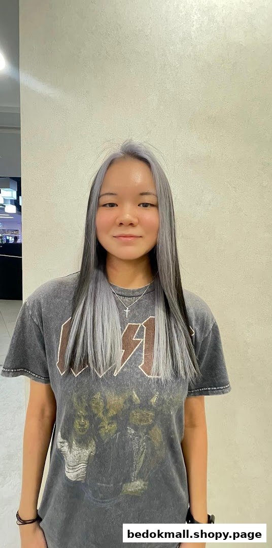 Young woman with long grey and black hair in a salon setting.