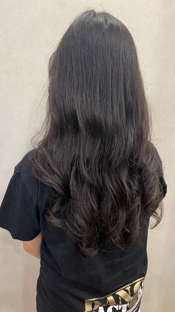 Back of person with long, dark, wavy hair.
