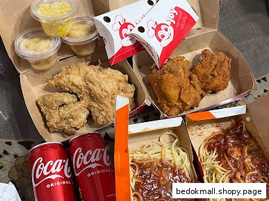 Jollibee fried chicken, spaghetti, sides, and sodas in takeout boxes.