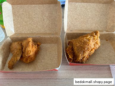 Two open cardboard boxes containing fried chicken pieces.