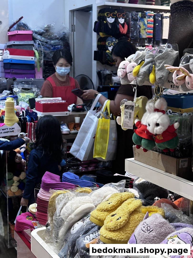 Interior view of a retail shop with products, staff, and customer at the counter.