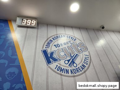 Interior wall with Kcuts logo and a digital queue number display.