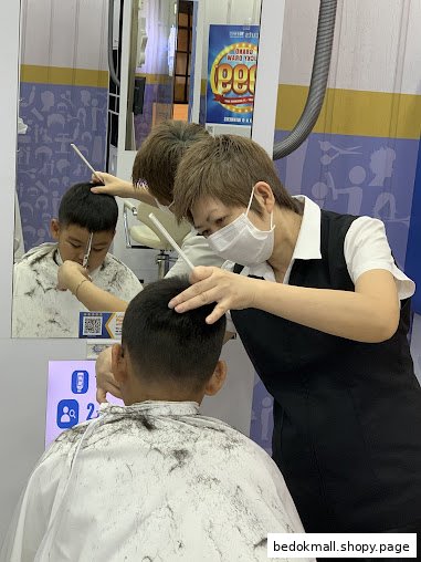 A stylist cuts a customer's hair inside a salon.