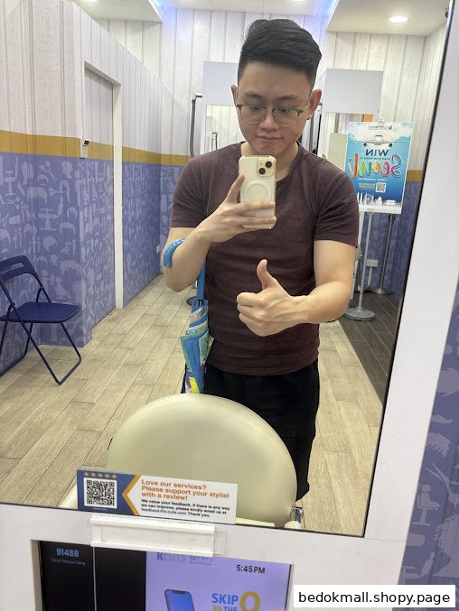 A person takes a selfie in a mirror inside a salon, showing the interior.