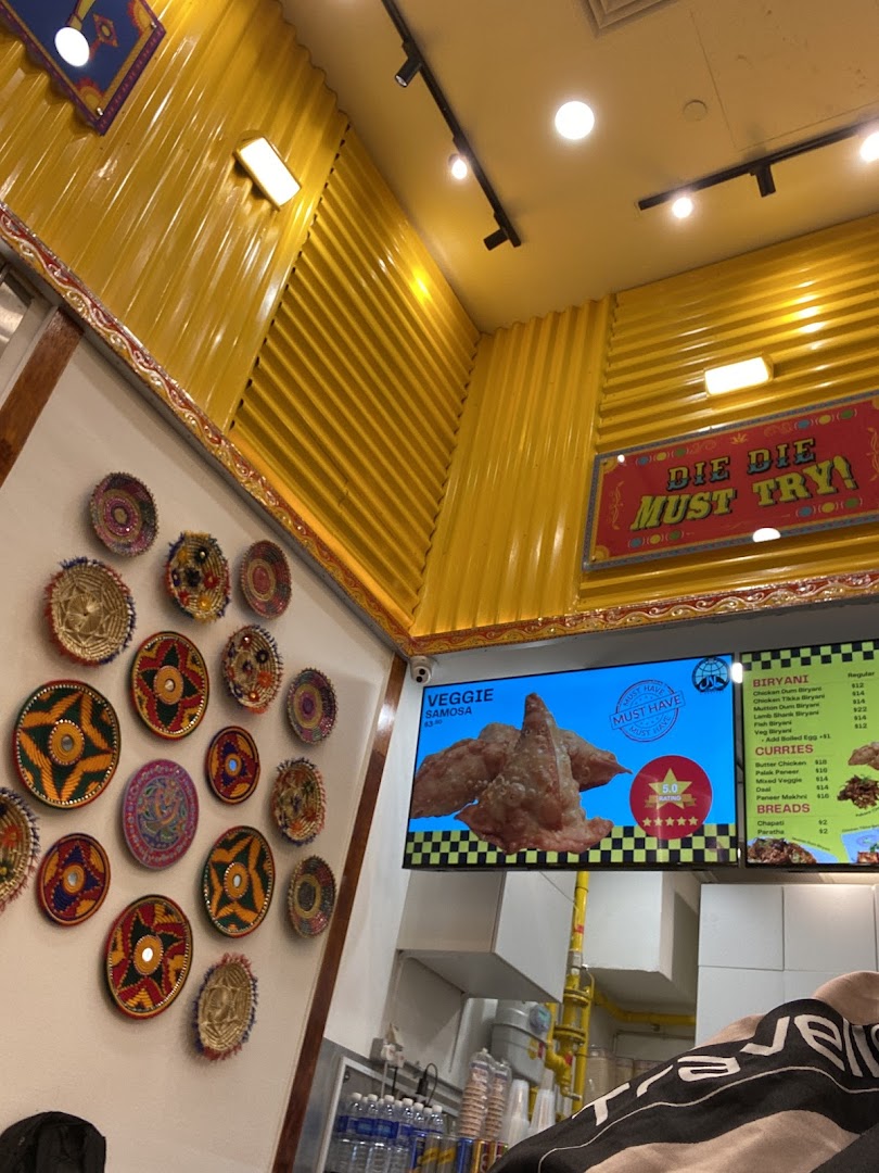 Interior view of a shop with decorative plates and a digital menu board.