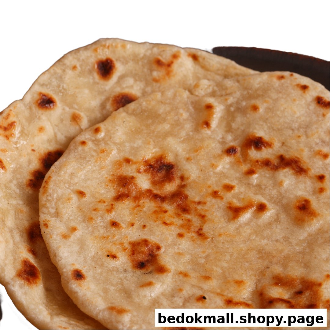 Two golden-brown flatbreads, possibly rotis, on a dark surface.