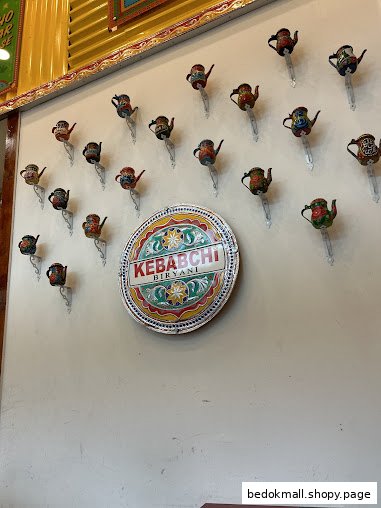 Interior wall decorated with colorful teapots and a Kebabchi Biryani sign.