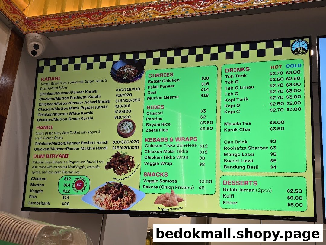 A vibrant digital menu board displaying a variety of Pakistani and Indian dishes with prices.