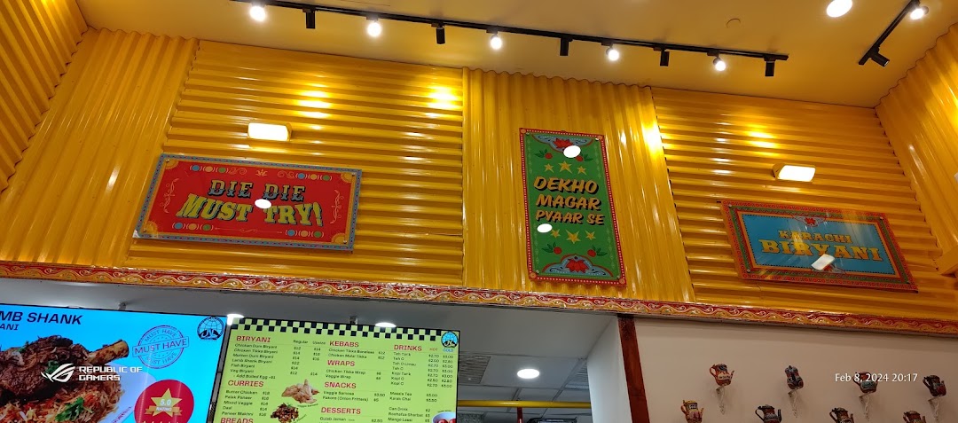 Interior view of a shop with yellow walls and a digital menu board.