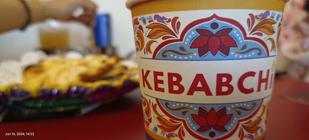 Close-up of a Kebabchi branded cup with food in the background.